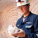 Rocanville Potash Corp underground production supervisor Dave Esslinger displays a sample of potash 1000 metres (3280 feet) below surface at the potash mine in Saskatchewan September 30, 2010. A far-reaching, independent report on the economic impact of a Potash Corp takeover will set the tone for a Canadian political response to BHP Billiton's $39 billion hostile bid or any other offer that surfaces. Picture taken September 30, 2010.